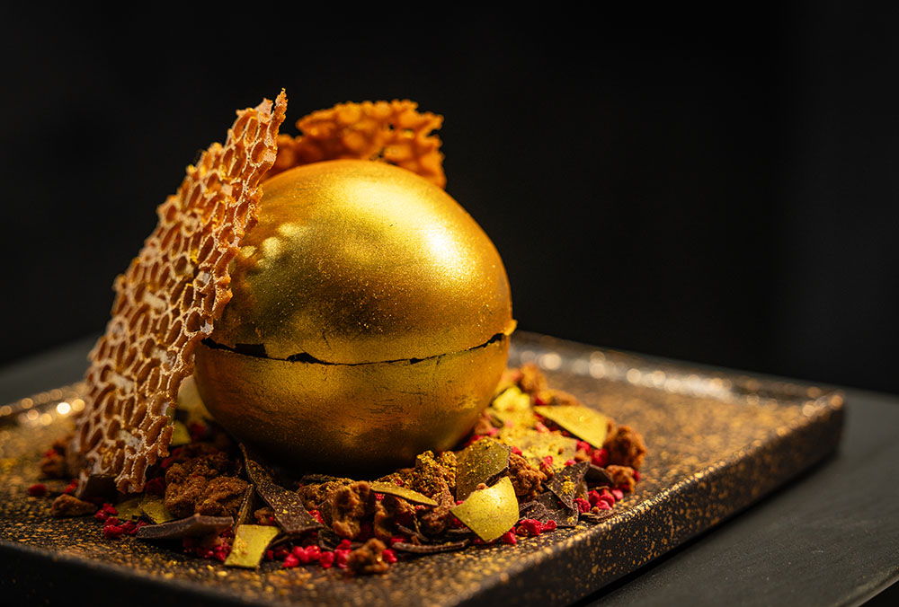 Michelin-inspired chocolate sphere with cake, ice cream, and salted caramel.